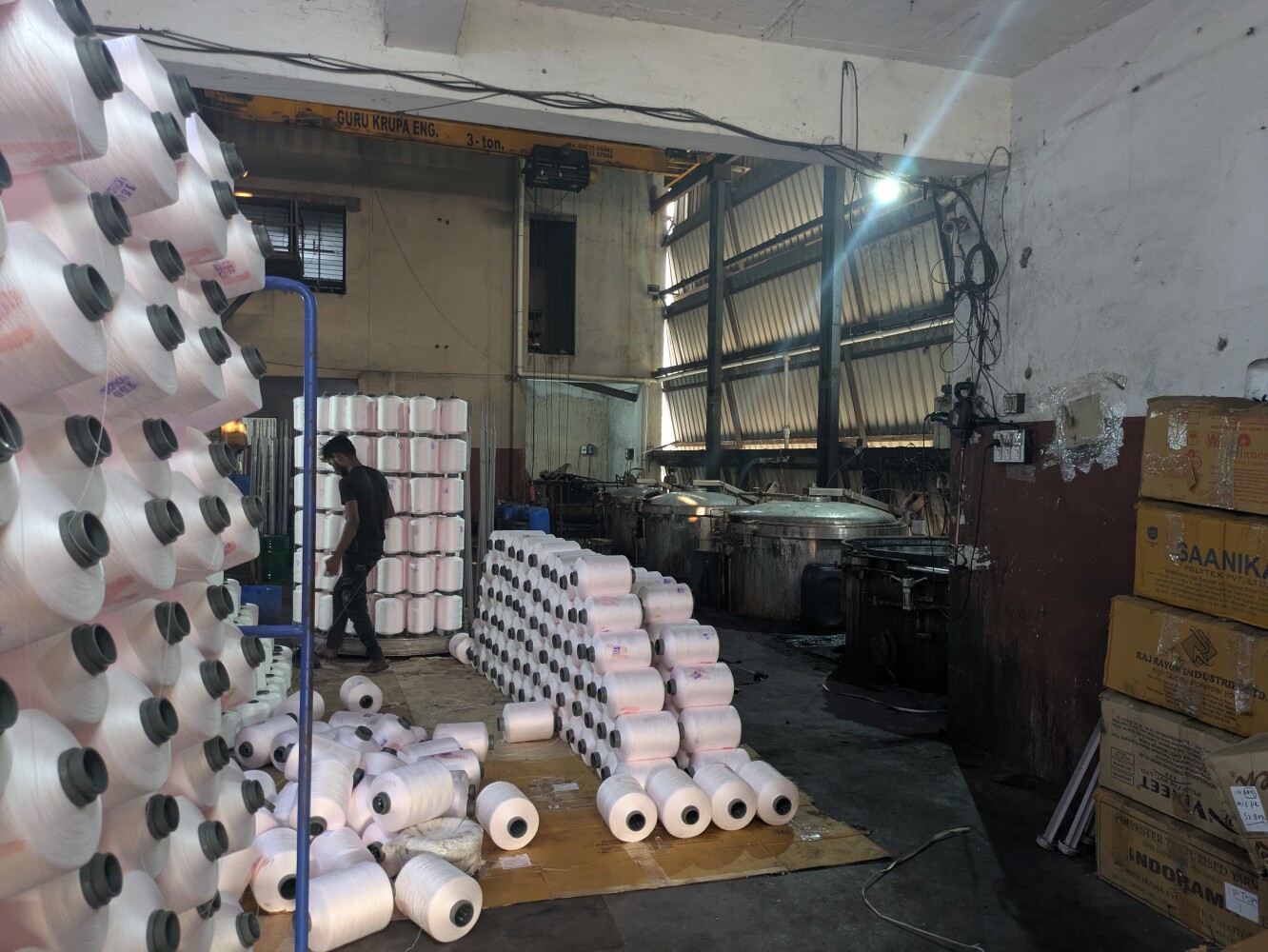These reels of polyester get dyed in the vats in the back